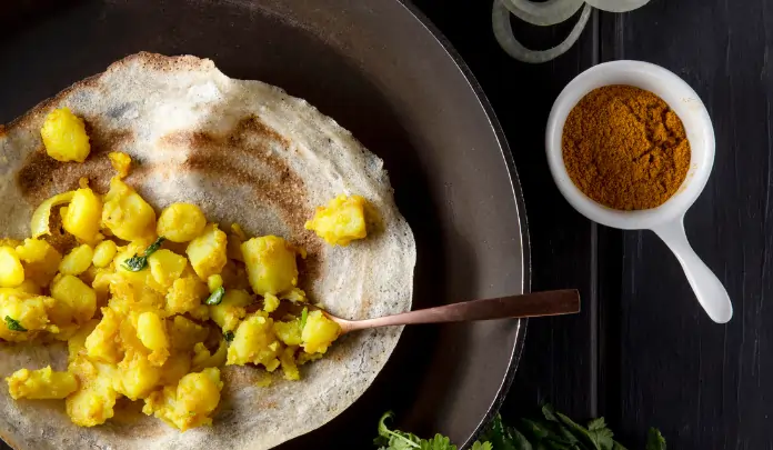 Crispy South Indian masala dosa with turmeric-spiced potato filling served on a plate