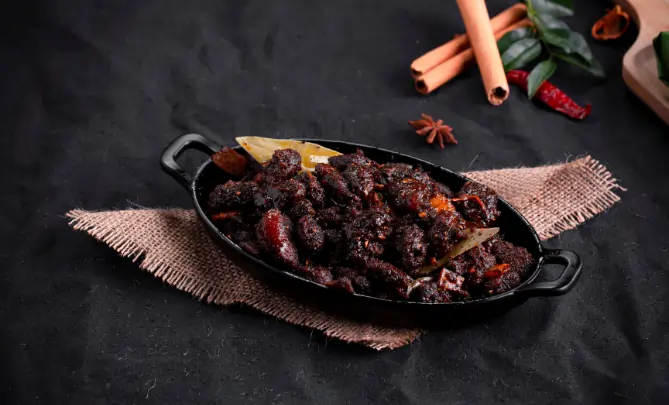 Traditional Kerala beef fry cooked with coconut slices curry leaves and spices
