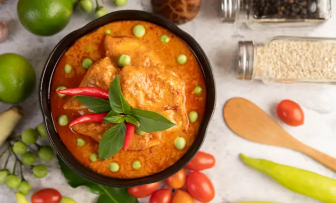 Traditional Kerala spicy fish curry with coconut gravy and red chilies in a bowl
